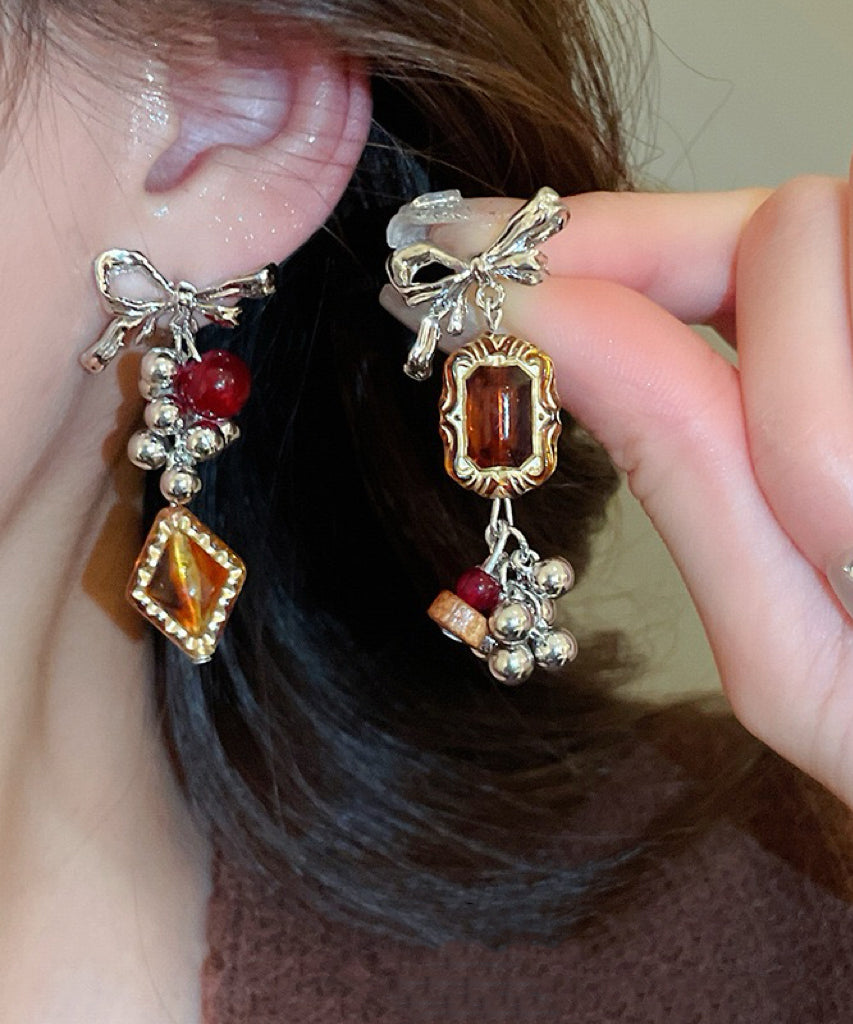 Boucles d'oreilles pendantes vintage asymétriques en alliage acrylique avec nœud ambré et pompon - Amawinc